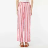 Pantalón ancho de punto gofrado color rosa con rayas verticales rojas y cintura con cordón ajustable.