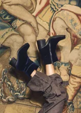 Botas de caña baja de velvet color azul marino, con efecto abullonado y cierre lateral con cremallera. Taco cuadrado y cadena desmontable con el logo de la marca.