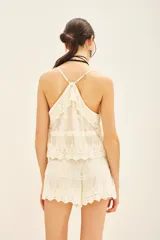 Musculosa color crema con breteles finos, escote en V y confeccionada en encaje floral forrado.