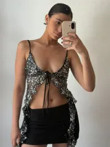 Top de fiesta negro con lentejuelas plateadas, escote en V y tirantes finos.