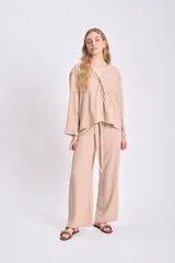 Pantalón color beige de corte ancho, con lazo ajustable en la cintura.