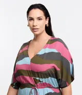 Vestido midi con estampado abstracto en tonos rosa, marrón, verde y celeste. Tiene escote en V, mangas cortas tipo murciélago y lazo ajustable en la cintura.