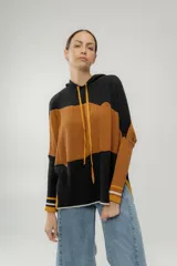 Canguro de punto con capucha, diseño a bloques de color negro, marrón y crudo, con cordones ajustables en color ocre.