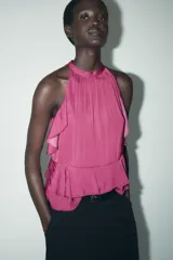 Top color fucsia de cuello halter con volantes en el mismo tejido. Cierre en la espalda con abertura y botones.