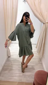 Vestido corto color verde militar, con cuello mao, botones frontales, mangas cortas acampanadas y volados en el ruedo. Confeccionado en lino. Fabricado en Italia.