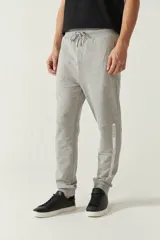 Pantalón de jogging negro de felpa con puños y cintura ajustable con cordón. Presenta logo de goma en la pierna izquierda y bolsillos laterales.