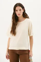 Blusa color crudo de lino con cuello redondo y mangas cortas.