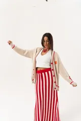 Saco oversize tejido con ilustraciones inspiradas en corales, peces, estrellas de mar y tortugas. Presenta galón picot en rojo en cartera y puños, y botones a tono.