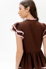 Vestido midi amarillo de lino, con volados en las mangas y detalle de volados y botones a lo largo del frente. Presenta un corte con talle marcado y falda escalonada.