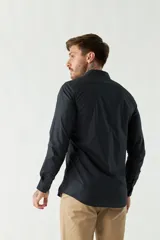 Camisa de vestir azul marino, de corte slim fit, manga larga y cuello clásico. Confeccionada en algodón y con logo bordado en el pecho.