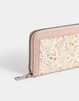 Billetera de cuerina color blanco crudo con cierre circundante y moño en relieve.