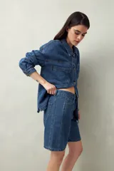 Bermuda de jean azul de corte clásico y largo a la rodilla.