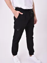 Pantalón jogger negro con cintura elástica ajustable con cordón, bolsillos laterales y un bolsillo cargo en la pierna izquierda.
