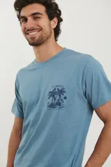 Remera celeste con estampado de palmeras y texto "St. Martin" en el pecho.