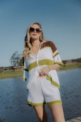 Conjunto tejido de algodón a rayas horizontales color blanco y marrón, compuesto por una camisa de manga corta con cuello polo y botones, y un short de tiro alto con cintura elástica. Incluye cordón de cuero marrón.