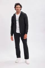 Campera deportiva negra con capucha y cierre frontal.