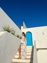 Vestido largo de crepé estampado en tonos verde y naranja, con escote en V, mangas largas abullonadas y abertura lateral en la falda.