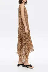Vestido midi con estampado de leopardo, escote redondeado pronunciado en el delantero, pico pronunciado en la espalda y volados asimétricos. Incluye cinta de algodón en la espalda a modo de lazo.