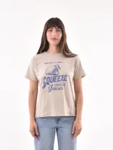 Remera color beige con estampado frontal de un limón y la frase "When you get lemons, squeeze them for creative juices".