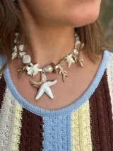 Collar corto con cuentas de nácar en diferentes formatos, perla natural XL y medallón de resina. Se cierra con cadena de acero quirúrgico y ganchito para regular el largo.