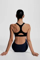 Top deportivo negro de soporte alto, confeccionado en tejido funcional ShapeMove™ y DryMove™. Cuenta con copas forradas con relleno extraíble, breteles anchos ajustables, espalda nadadora de malla y cierre de corchetes.