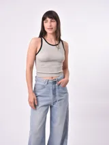 Musculosa negra de punto acanalado con cuello redondo y ribete blanco en cuello y sisas.