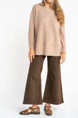 Sweater color beige de tejido texturado, con cuello redondo y mangas largas.