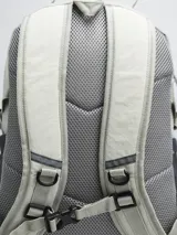 Mochila gris claro y gris oscuro con cordones elásticos cruzados en el frente y logo de la marca en la parte superior.