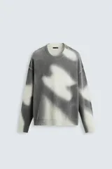 Sweater de punto gris con estampado difuminado en blanco, de corte relaxed fit, cuello redondo y mangas largas con terminaciones en rib.