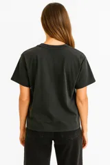 Remera de manga corta color blanco, corte holgado y cuello redondo. Presenta un estampado frontal con un diseño de sello postal con flores de cerezo.