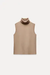 Top color beige de cuello alto y sin mangas.