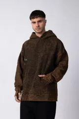 Buzo canguro marrón con capucha, de corte oversize y estética lavada.