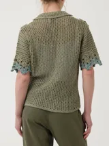 Chaleco tejido a crochet con diseño de flores en tonos beige y crudo, con cuello camisero y cierre frontal con botones de madera.