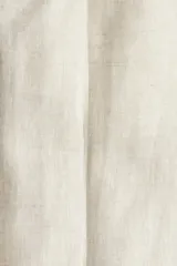 Pantalón de traje de lino color beige, corte slim fit, con cierre y corchete oculto, bolsillos laterales y traseros ribeteados.