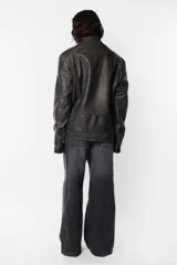 Chaqueta de cuerina pu opaca efecto vintage gastada, de silueta “oversize”. Acceso delantero mediante cierre metálico desmontable color dark niquel, con cartera interna pespunteada en zig zag de misma tela base. Cuello mao con snap y hombreras matelaseadas. Bolsillos delanteros con cierre metálico dark niquel Los ubicados en la parte superior son falsos. Terminación en manga con cierre metálico dark niquel para ajustar puño Por su interior, forrería matelaseada y bolsillo oculto en lado izquierdo superior con cierre invisible.