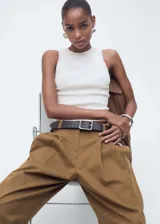 Musculosa blanca de tejido de punto fino, cuello redondo, tirantes anchos y diseño entallado.