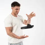 Chanclas negras con la palabra "GAIN" en relieve en la tira superior y "AMBITION" en el lateral de la suela.