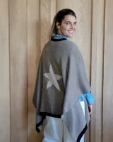 Ruana color gris con una estrella blanca estampada en la espalda y ribete negro.