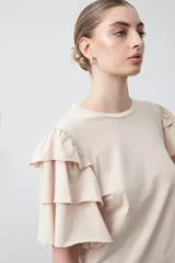 Remera negra de algodón con cuello redondo y mangas cortas con volados en capas.