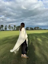 Zapatillas bajas con estampado animal print de vaca en blanco y negro, con cordones marrones y suela color caramelo.