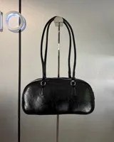 Cartera negra de cuero sintético con doble asa corta y cierre superior con cremallera.