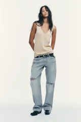 Top de punto color beige, con escote en pico y sisas anchas.