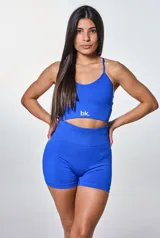 Conjunto deportivo azul eléctrico, compuesto por un top corto con tirantes finos y logo 'bk.' en el frente, y un short ajustado de tiro alto.