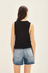 Top sin mangas color negro con escote en U pronunciado, tejido en punto compacto de textura sedosa y brillante.