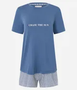 Conjunto de pijama short doll, compuesto por una remera azul con estampado de la frase "Chase The Sun" y un short a rayas verticales blancas y azules con cintura elástica.