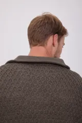 Sweater de punto trenzado color marrón con cuello alto y cierre de cremallera.