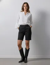 Bermuda de jean elastizada azul, marca One Five One. Pretina con pasadores, botón y cierre. Delantera con bolsillos. Trasera con bolsillos simulados.