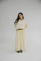Falda midi color crema, amplia y de corte evasé, confeccionada en viscosa y lino, con bolsillos laterales y cintura alta.