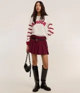 Suéter blanco de jacquard con letras 'Amour' en rojo y rayas horizontales rojas en las mangas.