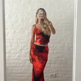 Conjunto de top corto con breteles finos y falda larga ajustada, ambos con estampado floral en tonos rojo y negro.